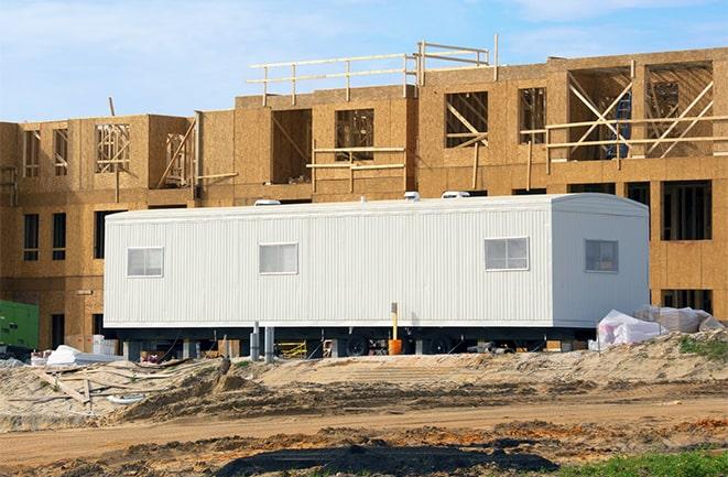 workers studying blueprints in a temporary rental office in Manvel, TX